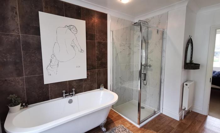 Large ensuite bathroom with a pretty freestanding bath and separate shower cubicle
